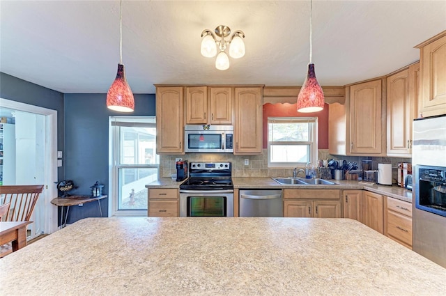 kitchen featuring sink, appliances with stainless steel finishes, hanging light fixtures, backsplash, and light brown cabinetry