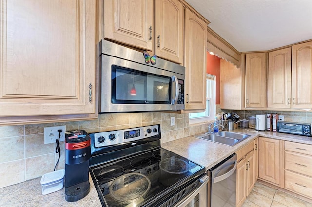 kitchen with light brown cabinetry, sink, decorative backsplash, and appliances with stainless steel finishes