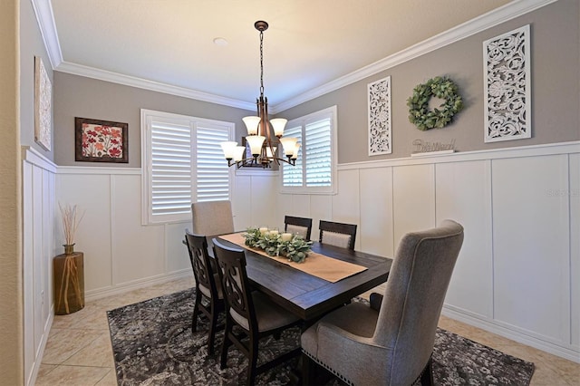 tiled dining space with an inviting chandelier and ornamental molding