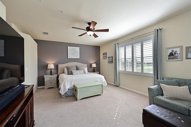 carpeted bedroom with ceiling fan and a textured ceiling