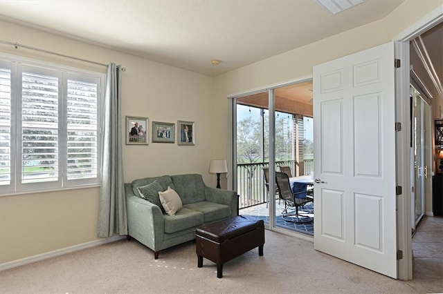 living area featuring a wealth of natural light and light colored carpet