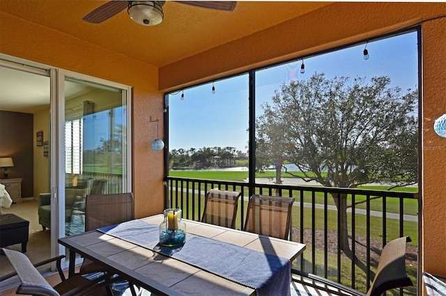 sunroom featuring a water view, a healthy amount of sunlight, and ceiling fan