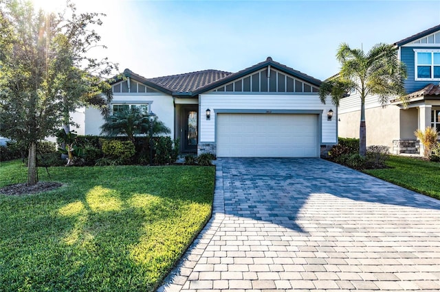 view of front of property featuring an attached garage, decorative driveway, and a front yard