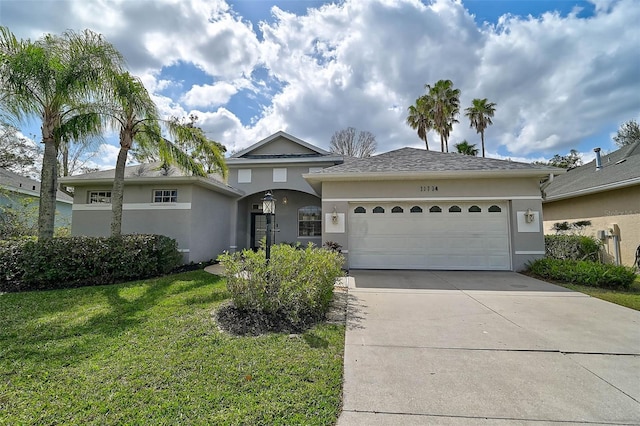 view of front facade with a garage, concrete driveway, a front lawn, and stucco siding