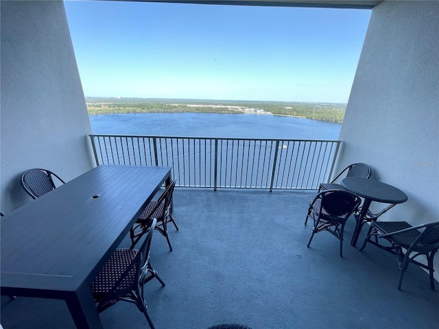 balcony featuring outdoor dining area and a water view