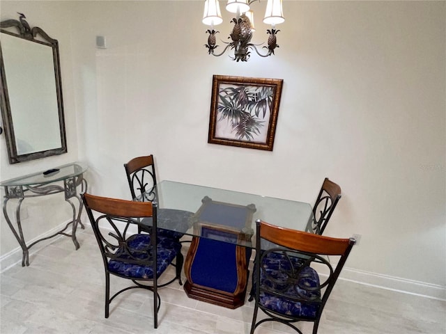 dining room featuring baseboards and a notable chandelier