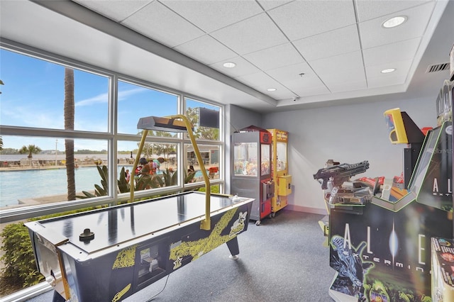 game room with a paneled ceiling, a raised ceiling, a water view, visible vents, and recessed lighting