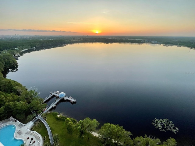 aerial view at dusk featuring a water view