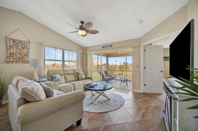 living room featuring ceiling fan, a healthy amount of sunlight, and vaulted ceiling