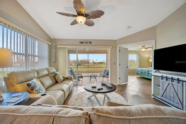 living room featuring lofted ceiling, tile patterned flooring, and a textured ceiling