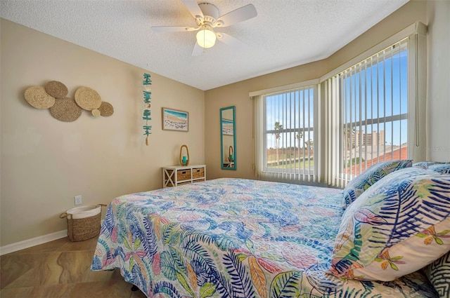 bedroom with ceiling fan and a textured ceiling