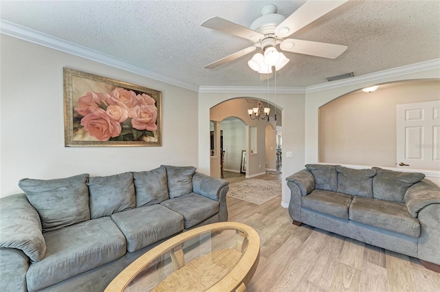 living room with ceiling fan with notable chandelier, ornamental molding, light hardwood / wood-style floors, and a textured ceiling