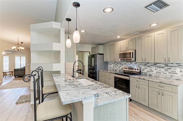 kitchen with sink, appliances with stainless steel finishes, backsplash, a kitchen breakfast bar, and kitchen peninsula