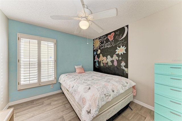 bedroom with ceiling fan, light hardwood / wood-style flooring, and a textured ceiling