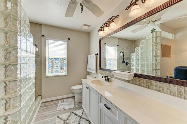 bathroom with a healthy amount of sunlight, vanity, hardwood / wood-style flooring, and ceiling fan