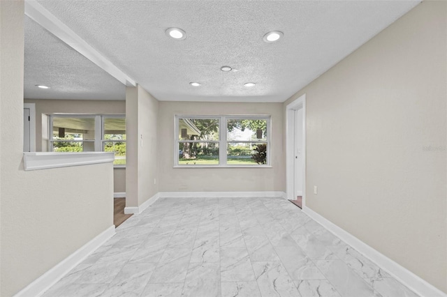 empty room with plenty of natural light and a textured ceiling