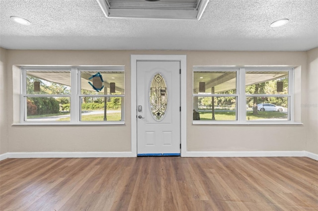 entrance foyer featuring wood-type flooring, a healthy amount of sunlight, and a textured ceiling