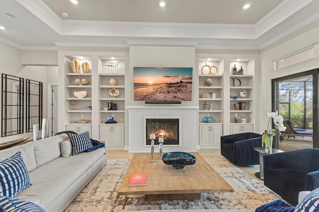 living room with a raised ceiling, ornamental molding, built in features, and light hardwood / wood-style floors