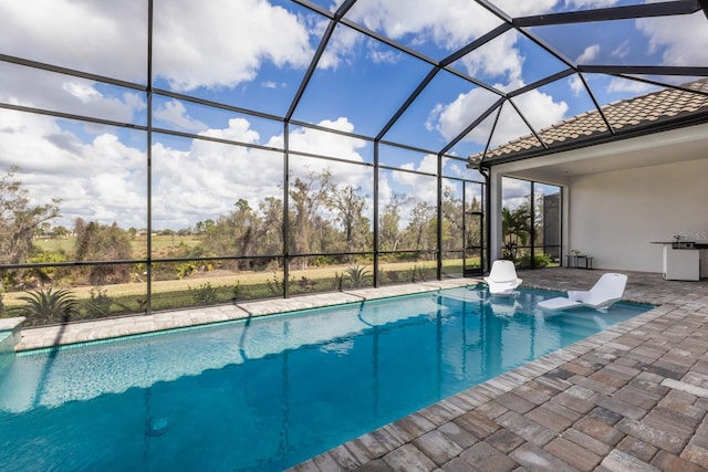 view of swimming pool with glass enclosure and a patio area