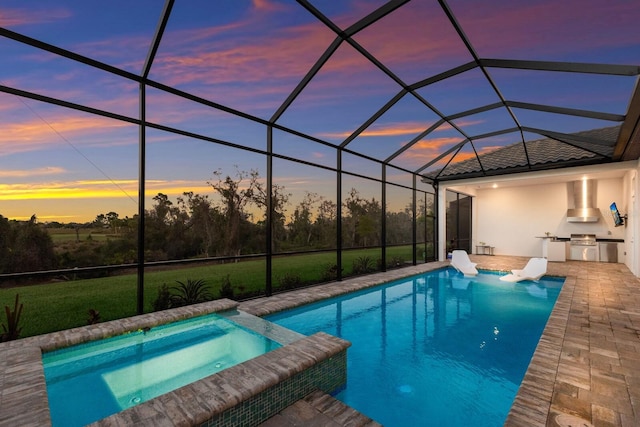 pool at dusk featuring a patio, an outdoor kitchen, an in ground hot tub, and a lanai