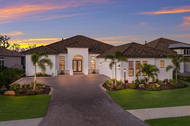 mediterranean / spanish-style house featuring a yard and french doors