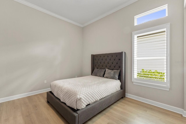 bedroom with crown molding and light hardwood / wood-style flooring