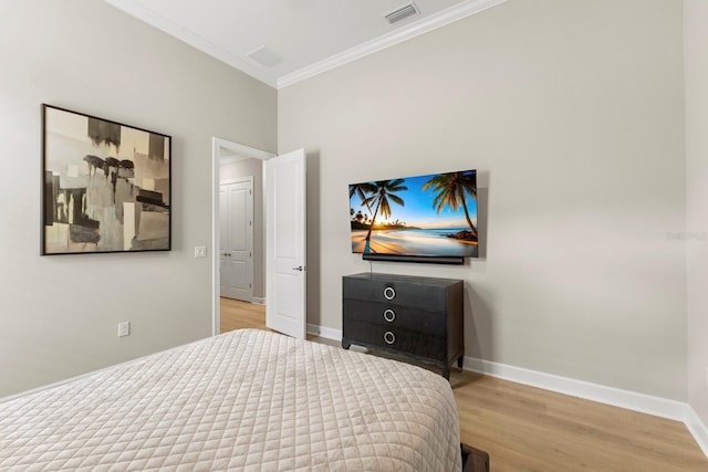 bedroom with crown molding and light hardwood / wood-style flooring