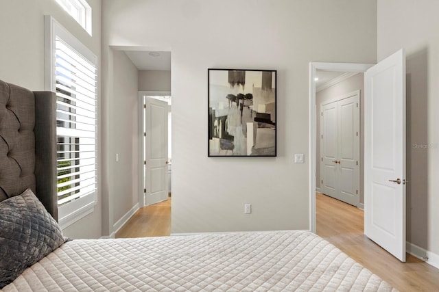 bedroom with ornamental molding and light hardwood / wood-style floors