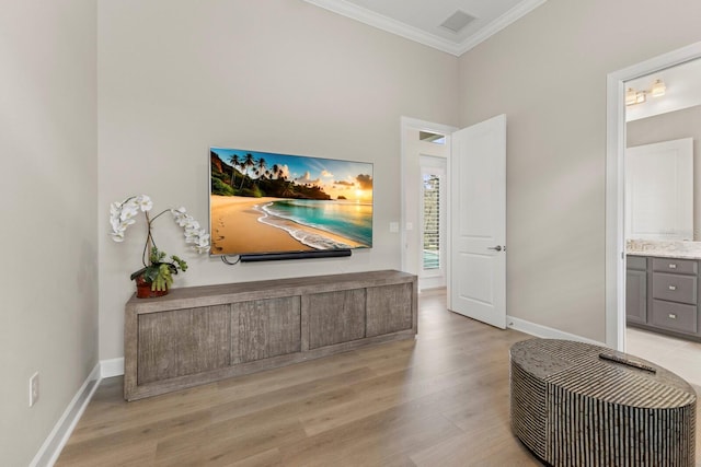 living area with crown molding and light hardwood / wood-style flooring