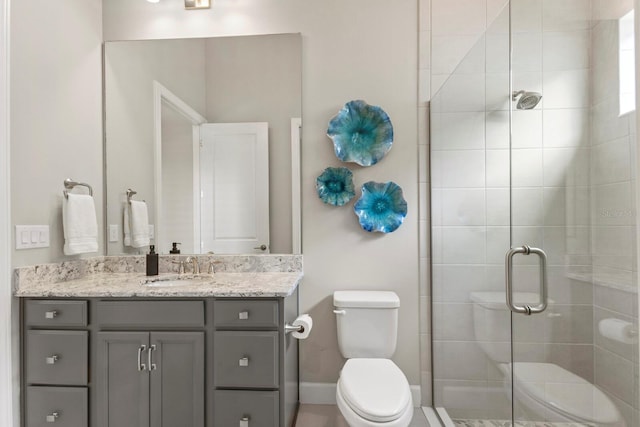 bathroom featuring vanity, toilet, and an enclosed shower