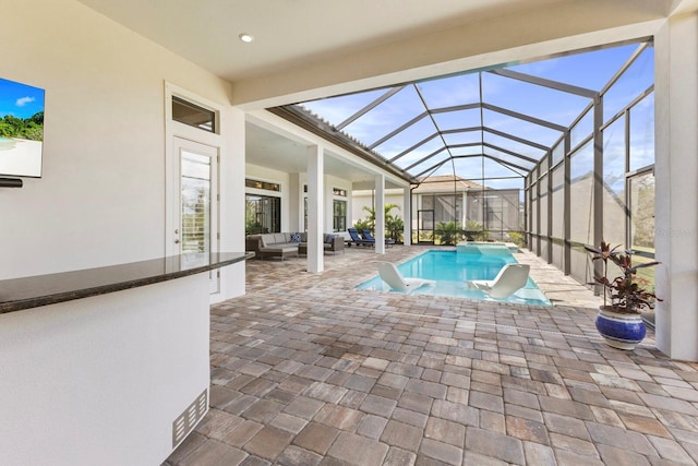 view of pool featuring an outdoor hangout area, glass enclosure, and a patio