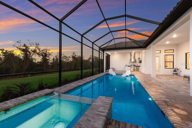 pool at dusk featuring area for grilling, a patio area, and glass enclosure