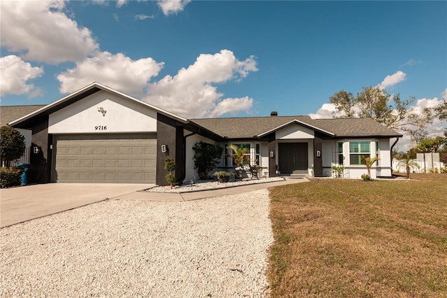 ranch-style home with a garage and a front lawn