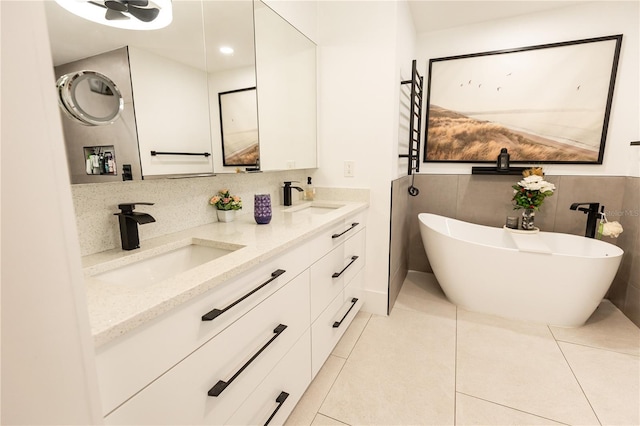 bathroom featuring double vanity, a soaking tub, a sink, and tile patterned floors