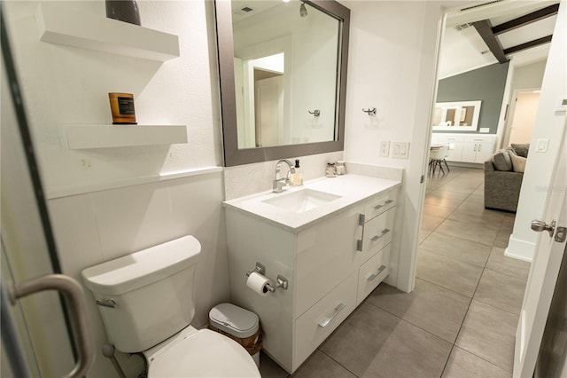 bathroom featuring vaulted ceiling with beams, vanity, toilet, and tile patterned floors