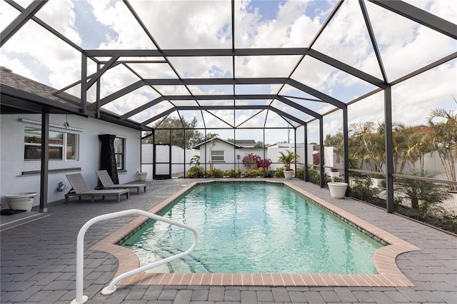 pool featuring a lanai, fence, and a patio