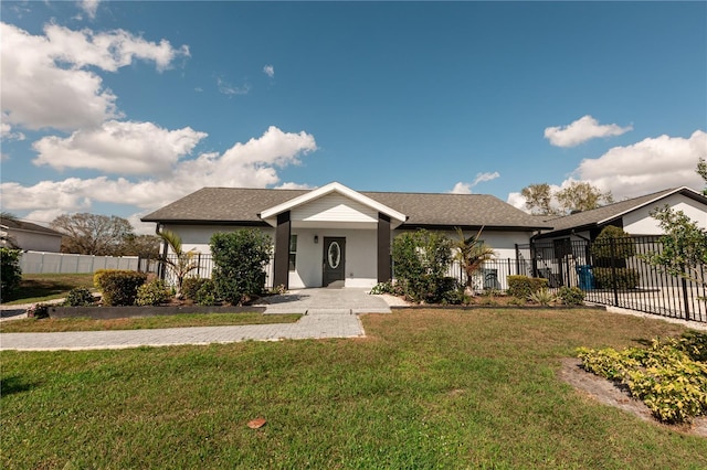 view of front facade featuring a front yard, fence, and stucco siding