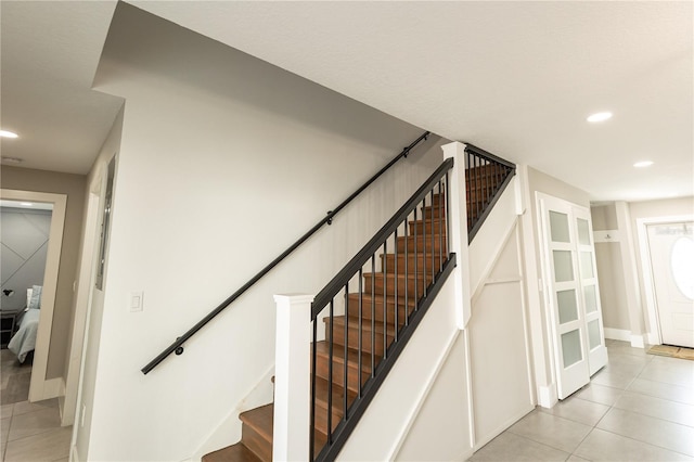 stairs with baseboards, recessed lighting, and tile patterned floors