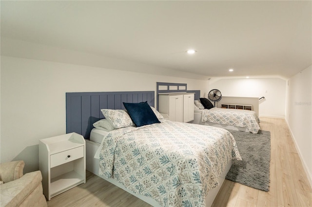 bedroom with lofted ceiling, light wood-style floors, baseboards, and recessed lighting