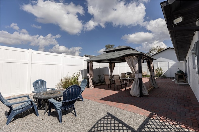 view of patio featuring a fire pit, a gazebo, outdoor dining area, and a fenced backyard