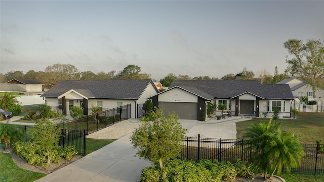 ranch-style house with a fenced front yard, driveway, and a garage