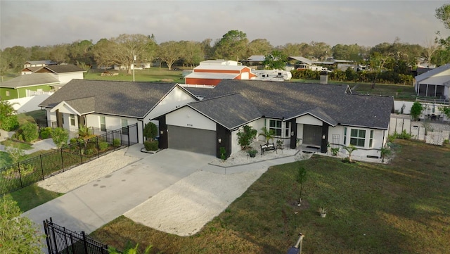 view of front facade featuring driveway, a residential view, and fence