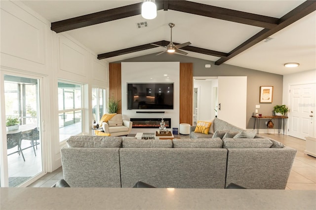 living area with a glass covered fireplace, visible vents, vaulted ceiling with beams, and light tile patterned flooring