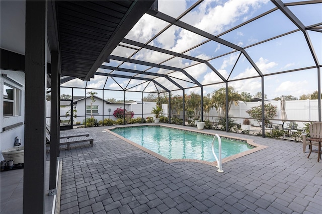 view of swimming pool with glass enclosure, a patio area, fence, and a fenced in pool