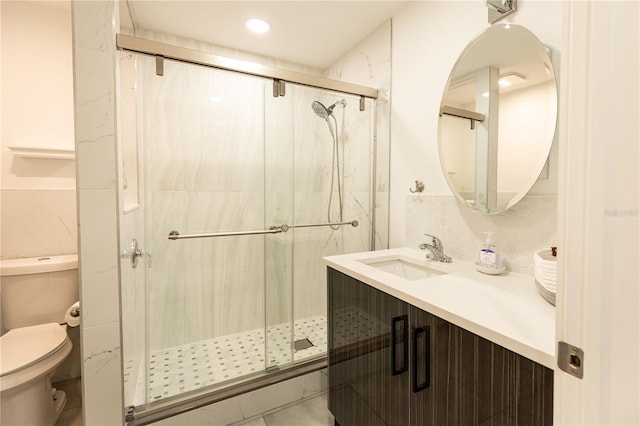 full bathroom featuring decorative backsplash, a shower stall, toilet, and vanity