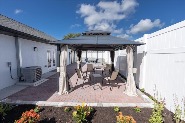 9716 28th St E, Parrish, FL 34219 - view of patio with cooling unit, a gazebo, a fenced backyard, outdoor dining space, and french doors