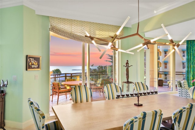 dining area featuring a water view, floor to ceiling windows, and crown molding