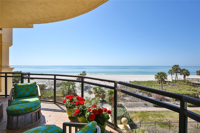 balcony featuring a view of the beach and a water view