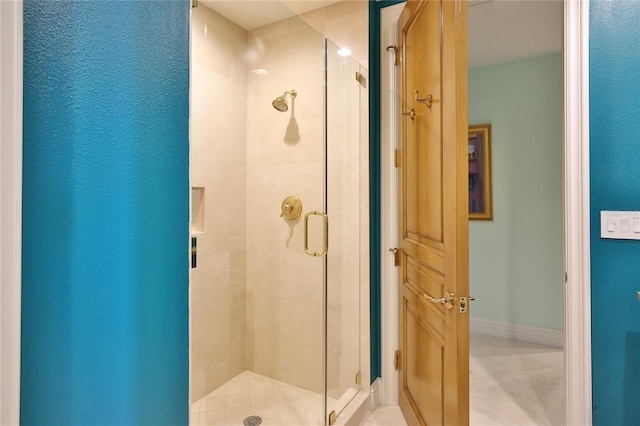 full bathroom featuring baseboards and a shower stall