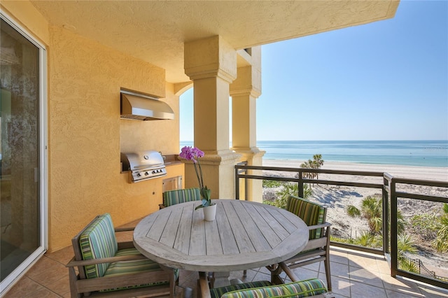 balcony featuring a view of the beach, area for grilling, outdoor dining area, and a water view